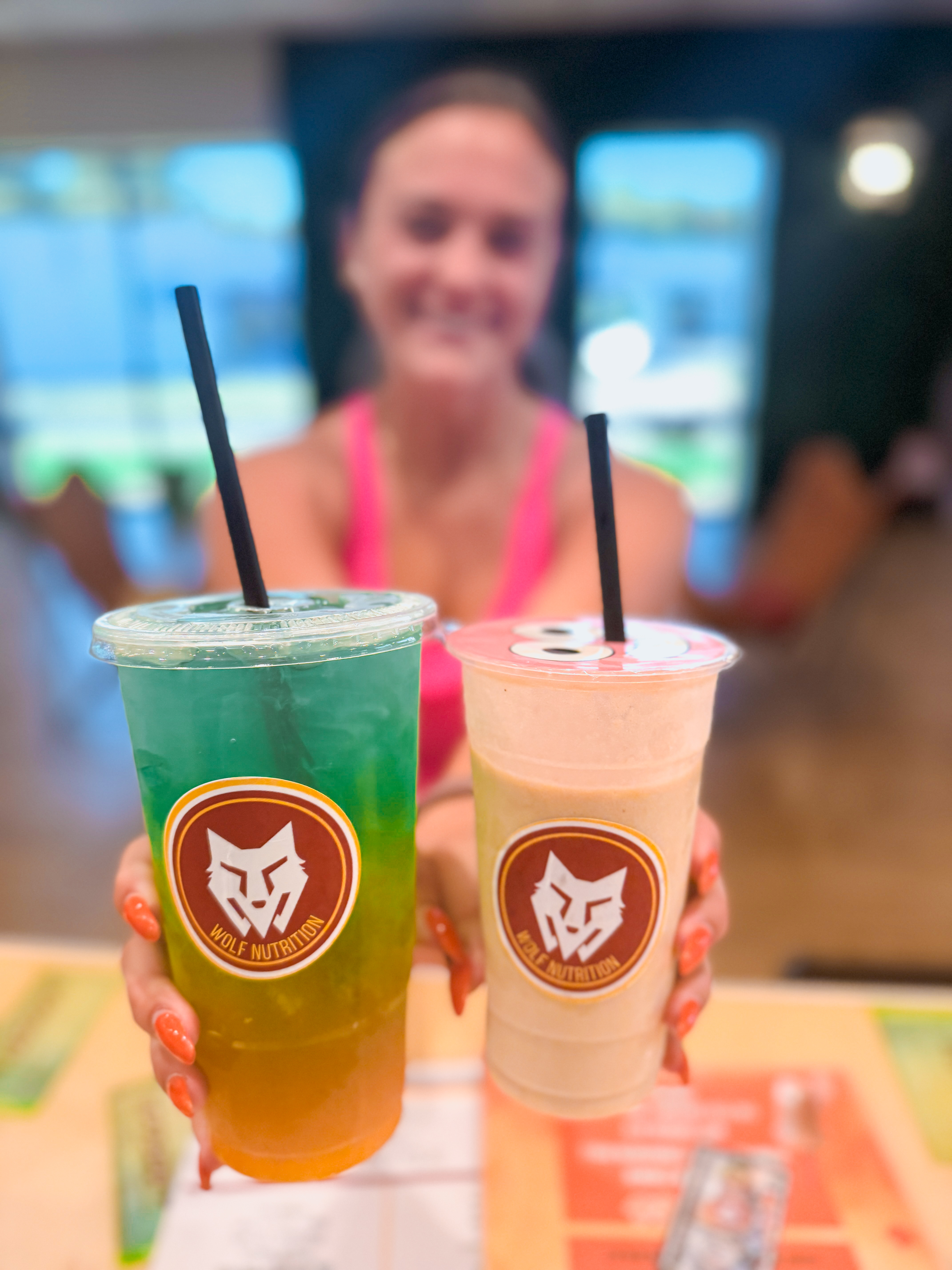 Two vibrant energy teas held up at Wolf Nutrition