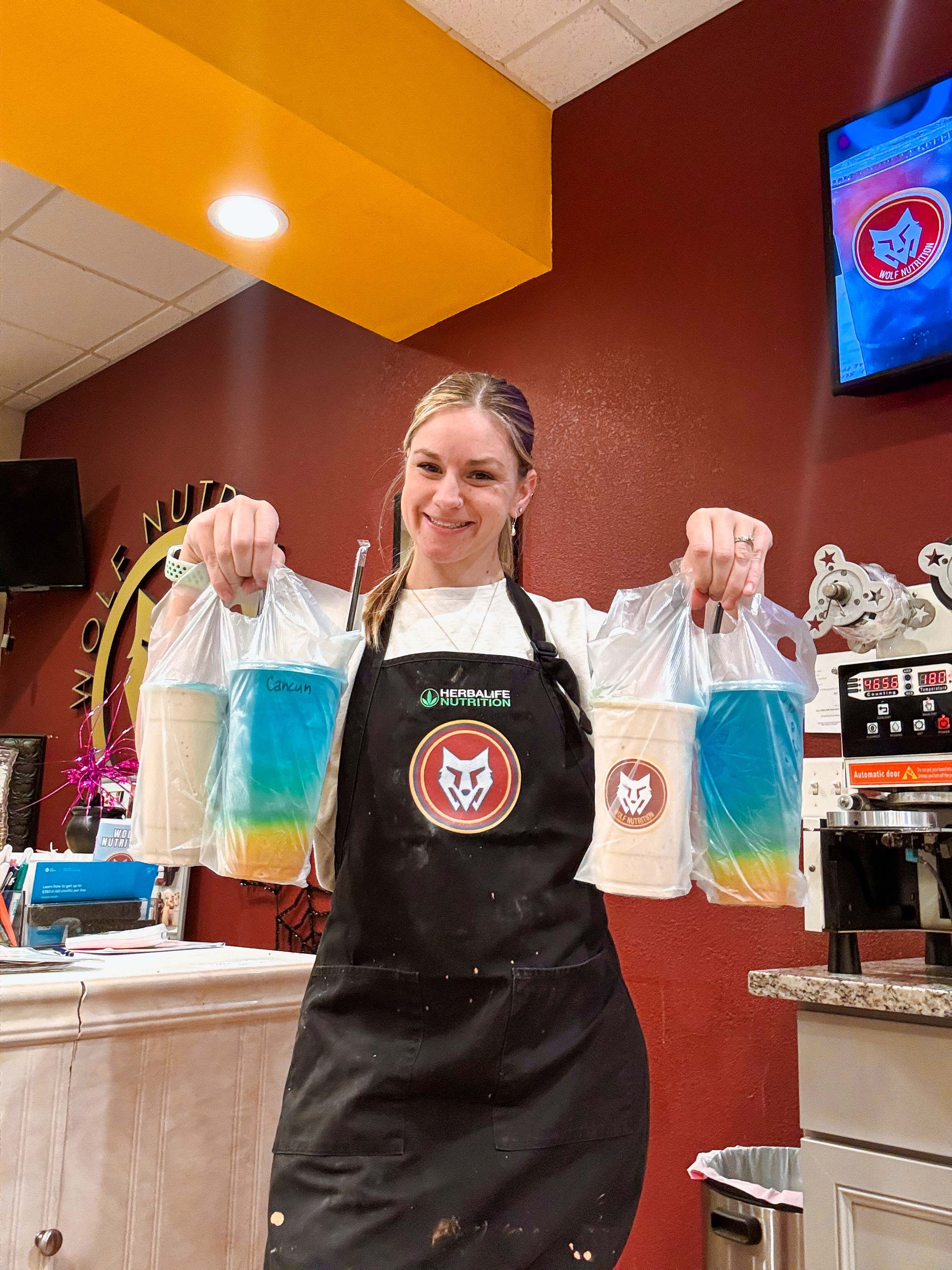 Wolf Nutrition staff member holding branded drink bags
