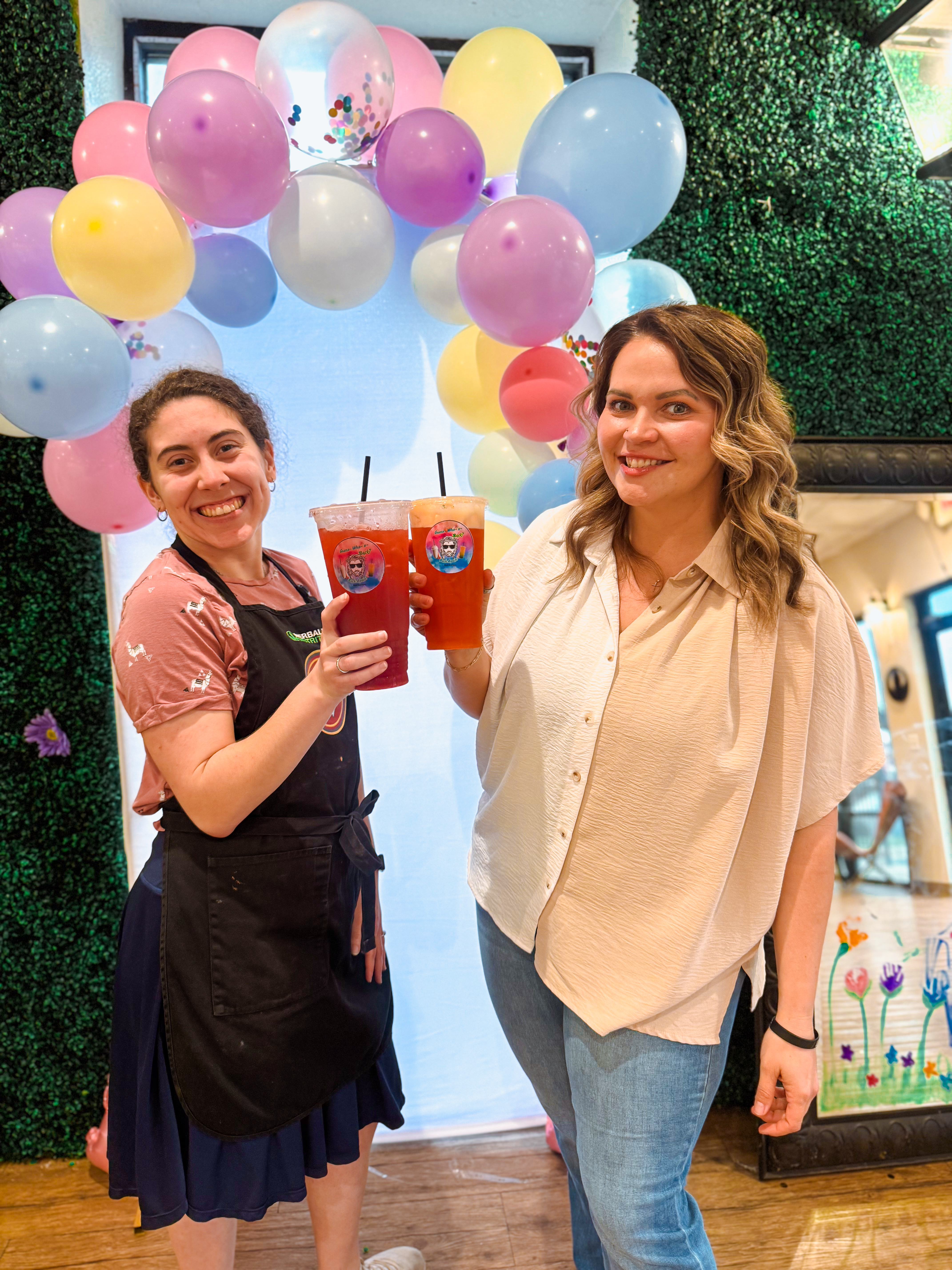 Staff and customers cheering with colorful drinks
